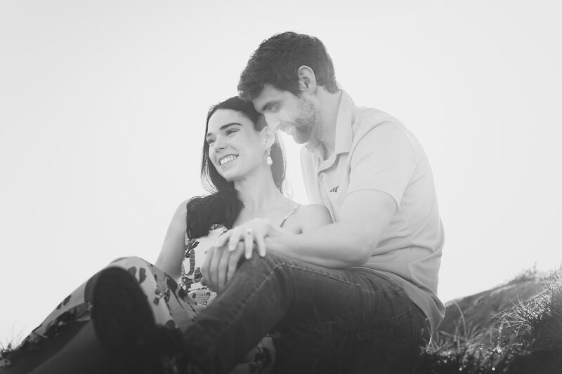 Theresa and Ryan sitting together on a hillside, Ryan smiling at her